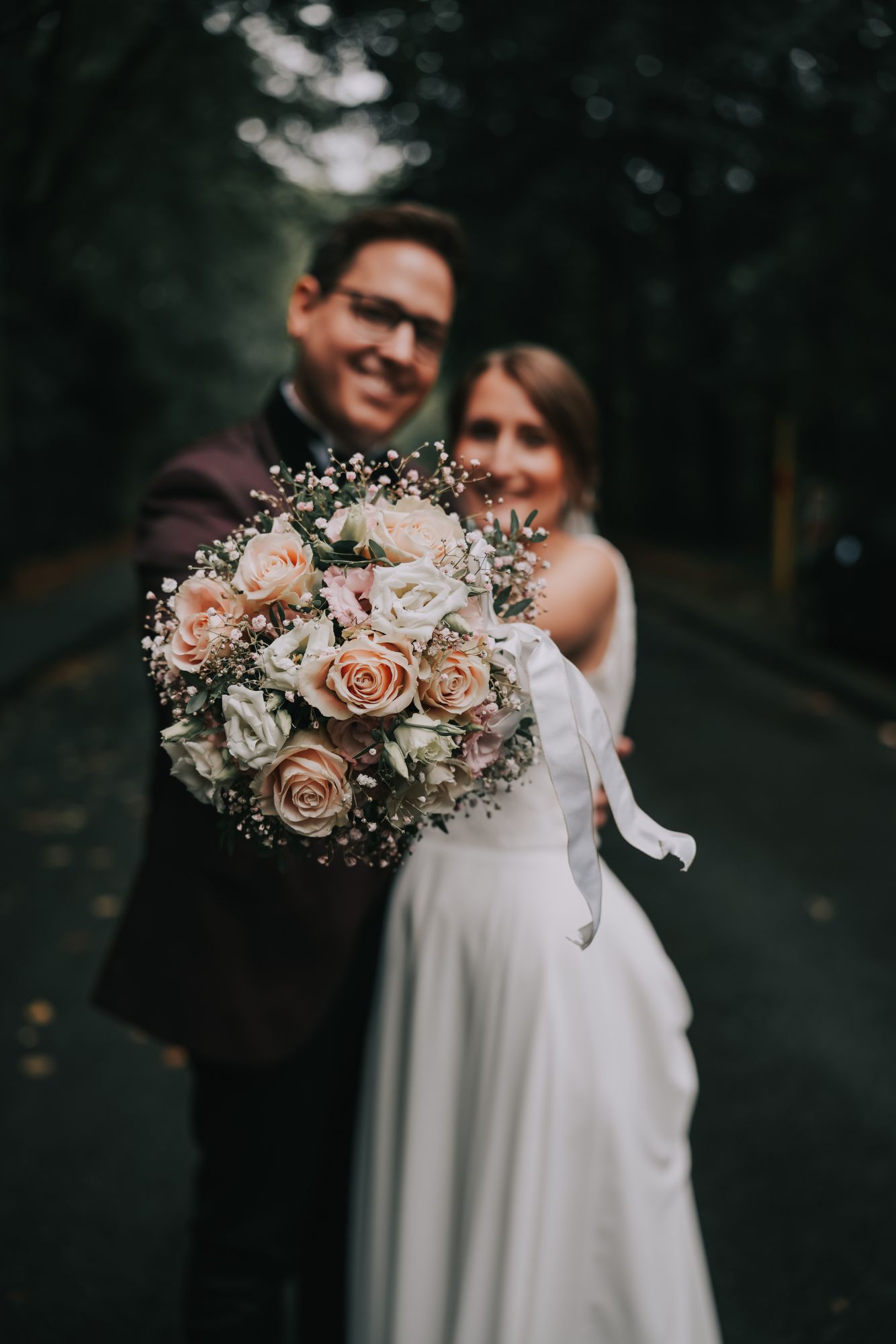 Ehepaar hält Blumenstrauß in die Kamera